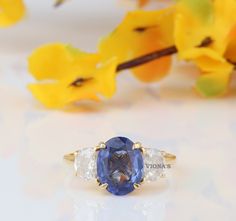 a blue and white ring sitting on top of a table next to some yellow flowers