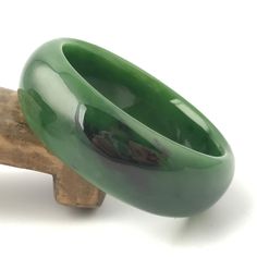 Siberian Jade Bangle. Measures approximately 50mm x 18mm. Formal Thick Band Bracelets With Polished Finish, Formal Thick Band Bracelet With Polished Finish, Carved Jade Bangle Bracelet, Elegant Round Band Jade Jewelry, Green Classic Bangle For Formal Occasions, Luxury Green Rectangular Bracelets, Luxury Thick Band Bracelets For Formal Occasions, Elegant Thick Band Bracelet As Gift, Elegant Thick Band Bracelet For Gift