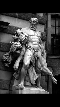 a black and white photo of a statue on the side of a building with a dog