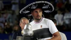 a man wearing a sombrero and holding a silver object in front of him