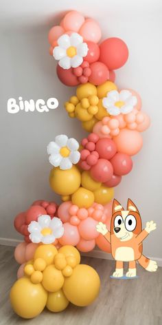 a bunch of balloons that are in the shape of a cat and some flowers on top of it