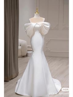 a white wedding dress on display in a room