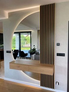 a living room filled with furniture and a large mirror on the wall next to it