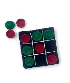 a crocheted board game with red and green balls