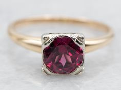 This is the classic, vintage solitaire ring with clean lines and great proportions. Featuring a bright white gold head to better frame the romantic rhodolite garnet. Polished, rounded yellow-gold shoulders complete the simple look. Metal: 14K Yellow and White Gold Gem: Rhodolite Garnet .88 Carats Gem Measurements: 6.0 mm, Round Ring Size: 6.25 Marks: "14K" Stamped on the inside band SKU #: A47283 Each piece has been identified and graded by a Graduate Gemologist who has been certified by the Gemological Institute of America (GIA). We have six brick-and-mortar storefronts in Maine, Massachusetts, and New Hampshire and have been in business for over 25 years! Please visit our Shop's About Page or our website for more information about our jewelry. For questions about diamond grading, we reco Gold Garnet Ring, Retro Era, Simple Ring, Ring Birthstone, Garnet Jewelry, Ring Simple, Garnet Ring, Rhodolite Garnet, Round Rings