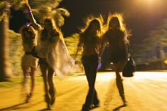 three women are walking down the street at night