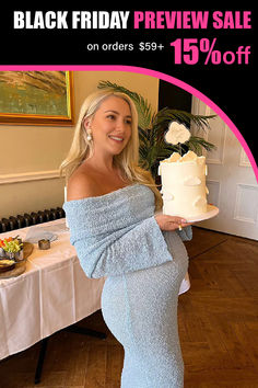 a pregnant woman holding a cake in front of a table with other items on it