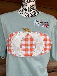 Adorable vintage distressed Pumpkin shirt that is stitched in an open edge vintage style bean stitch, and the fabric is purposely frayed.  This stitch allow the fabric to fray a little more with each wash.    You can choose between a Bella Canvas or Gildan soft style. Custom orders are done as well. Check out our Facebook page too. https://www.facebook.com/Needle-Nut-Embroidery-100913691324151/ Fall Patchwork Short Sleeve T-shirt, Fall Patchwork Short Sleeve Shirt, Vintage Distressed Cotton Shirt, Short Sleeve Patchwork T-shirt For Fall, Distressed Cotton Short Sleeve Shirt, Acid Wash Cotton T-shirt With Frayed Hem, Distressed Cotton Shirt With Short Sleeves, Distressed Cotton Shirt For Fall, Fall Cotton Tops With Frayed Hem