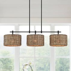 three light chandelier hanging over a dining room table with chairs in the background