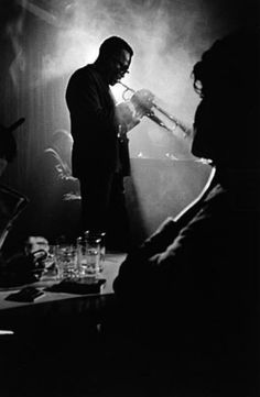 black and white photograph of two men talking to each other in front of a microphone