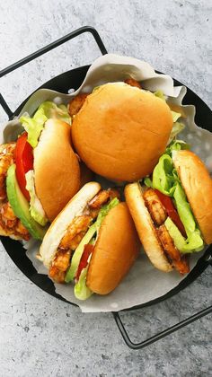 four chicken sandwiches on buns with lettuce and tomato