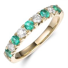 a gold ring with green and white stones