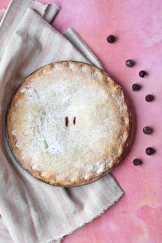 a pie sitting on top of a table next to coffee beans