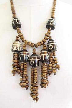 This stunning vintage necklace is a true statement piece! Featuring a cascade of unique, painted focal beads in shades of brown and cream, this necklace is sure to turn heads. The necklace measures approximately 22" long with a 5" drop, making it a versatile piece that can be dressed up or down. Details: Length: 22" Drop: 5" Material: Unknown Not so heavy as glass, but more heavy than wood.  Maybe petrified wood? I do not know Closure: Hook and Ring This necklace is in excellent vintage conditio Hook And Ring, Focal Beads, Jewelry Hand, Fringe Necklace, Festival Jewelry, Shades Of Brown, Beaded Fringe, Petrified Wood, Focal Bead