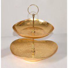 two tiered trays with handles are stacked on top of each other in gold