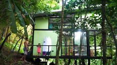 two people standing on the porch of a green house