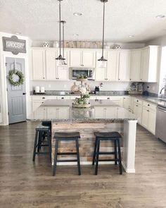 a kitchen with two stools and an island in front of the stove top oven