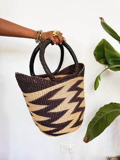 A beautiful authentic one-of-a-kind handwoven market basket tote handmade in Bogatanga. Each bag is beautifully woven by hand with thick, natural and dyed elephants grass to create a beautiful pattern and leather wrapped handles. This is the perfect market bag for trips to the farmers market, the beach, picnics or storage. Size: 13”H x 17”W x 10”D *One-of-a-kind, 1 of 1. Traditional Bucket Straw Bag With Leather Handles, Handwoven Natural Fiber Basket Bucket Bag, Traditional Bucket Straw Bag For Shopping, Artisan Straw Bucket Bag With Leather Handles, Handwoven Basket-shaped Bucket Bag For Market, Handwoven Basket Bucket Bag For Market, Artisan Handwoven Straw Bag For Shopping, Traditional Straw Tote Bag With Bamboo Handle, Traditional Natural Bucket Bag With Braided Handles