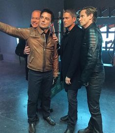 three men in leather jackets standing next to each other with one pointing at the camera