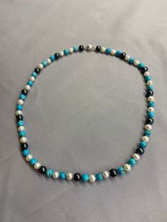 Black and White Pearls with Turquoise Necklace. This hand knotted necklace features 15 Black Freshwater Pearls AAA High Luster Round 7-7.5mm with blue and green overtones - 28 White Freshwater Pearls AAA High Luster round to near round 6-6.5mm - 28 Turquoise Polished Round Beads Genuine Natural Hubei 6.4-6.6mm they have been stabilized, finished with a 925 silver round bead clasp. The necklace measures 19 inches in length. I hand knotted this with white spectra thread, it should wear and hold up Blue Single Strand Round Pearl Necklace, Blue Single Strand Pearl Necklace, Black Freshwater Pearls, Hand Knotted Necklace, Knotted Necklace, Corpus Christi Tx, Gold Pearl Necklace, Pearl Choker Necklace, White Freshwater Pearl