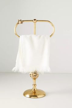 a gold towel holder with white towels on it