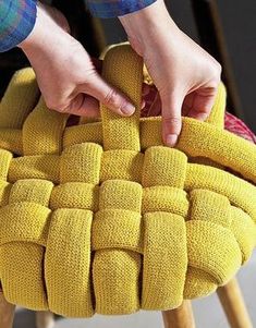 a person holding onto a yellow chair cushion