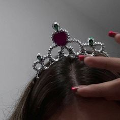 a close up of a person holding a tiara on their head with her hands