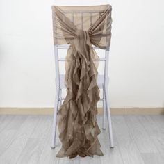 a chair with a brown ruffled cloth draped over it