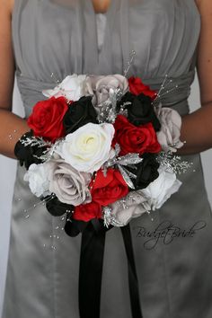 a bride holding a bouquet of red and white flowers