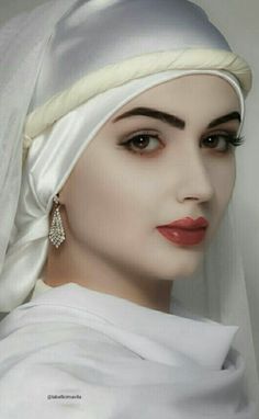 a woman wearing a white veil and earrings