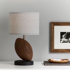 a football lamp sitting on top of a table next to a book and framed photograph