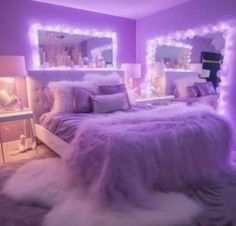 a bedroom with purple walls and white fur on the bed, along with two lighted mirrors