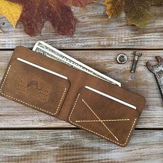 a leather wallet sitting on top of a wooden table next to a pair of scissors