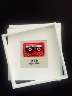 a cross stitch picture with a red tape cassette on it and the words rip printed in black