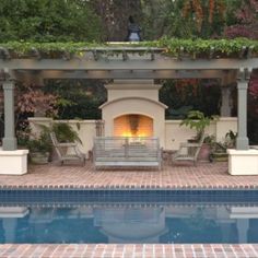 an outdoor fireplace in the middle of a swimming pool