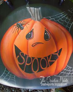 a painted pumpkin with the word spook on it's face and spider web