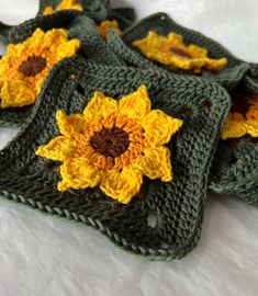 four crocheted sunflowers are sitting on top of each other in the shape of squares