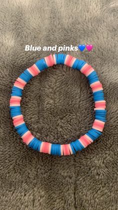 a blue and pink beaded bracelet on top of a gray blanket with the words blue and pinks written across it