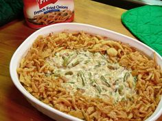 a white bowl filled with pasta and vegetables next to a can of french fried onions