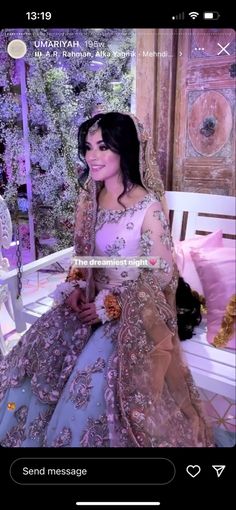 a woman sitting on top of a white bench wearing a purple and gold wedding dress