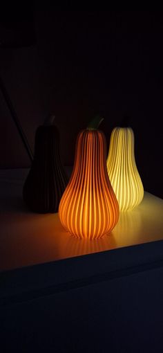 three different colored lamps sitting on top of a table