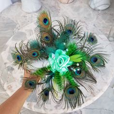 peacock feathers are arranged on top of a marble table with a rose in the center