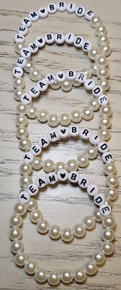 two bracelets that say team bride, team bride and team bride with pearls on them