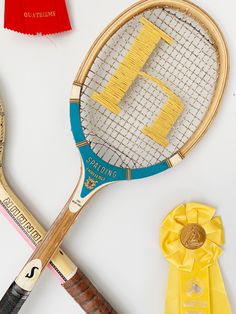 two tennis racquets, one with the letter h on it and another with a ribbon