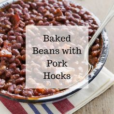 baked beans with pork hocks in a bowl on a striped napkin and wooden table