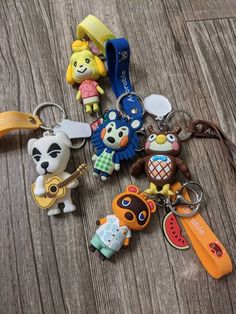 several keychains with cartoon characters on them sitting on a wooden table next to each other