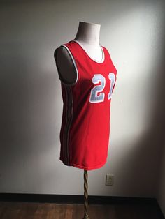 "Vintage spots sleeveless jersey label- Athletic Supply label size 38 (please go by measurements) red with grey and white side stripes and neck stripes 21 patches on front and back good condition w/wear normal to age no fabric info tag feels partly elastic/stretchy measures, lying flat, shoulder- 13 1/4\" chest- 18\" hem- 18 1/4\" length- 29\"" Collegiate Red Sleeveless Top, Red Collegiate Sleeveless Top, Red Sleeveless College Tops, Red Sleeveless Tops For College, Team Spirit Red Sleeveless Tops, Collegiate Sleeveless Tops For Sports Season, Sporty Sleeveless Tops For College, Team Spirit Sleeveless Tank Top For Sports, Collegiate Sleeveless Tank Top For Sports