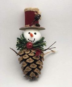 a snowman made out of pine cones with a top hat