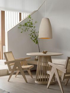 a table with chairs and a lamp in a room next to a stair case on the wall