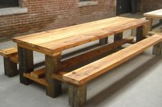 two wooden benches sitting next to each other in front of a brick wall and window